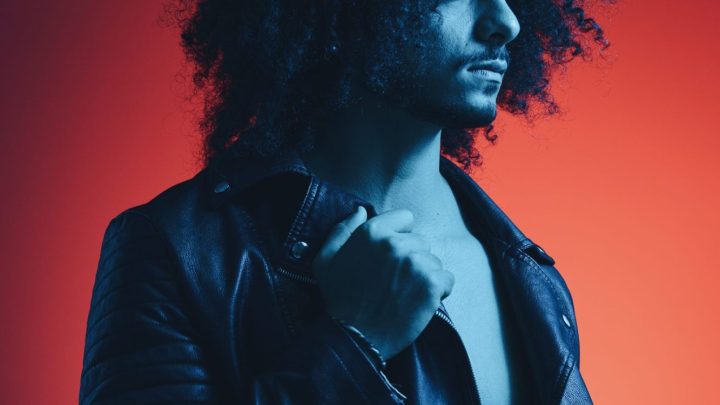 Portrait de JoeyStarr sur scène, un microphone à la main.